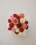 Bouquet of red, pink, and cream 3D chocolate roses on a light beige background