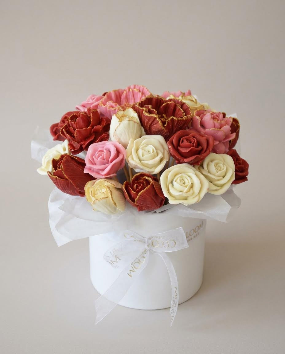 Decorative box with red, pink, and white 3D chocolate flowers on a light background