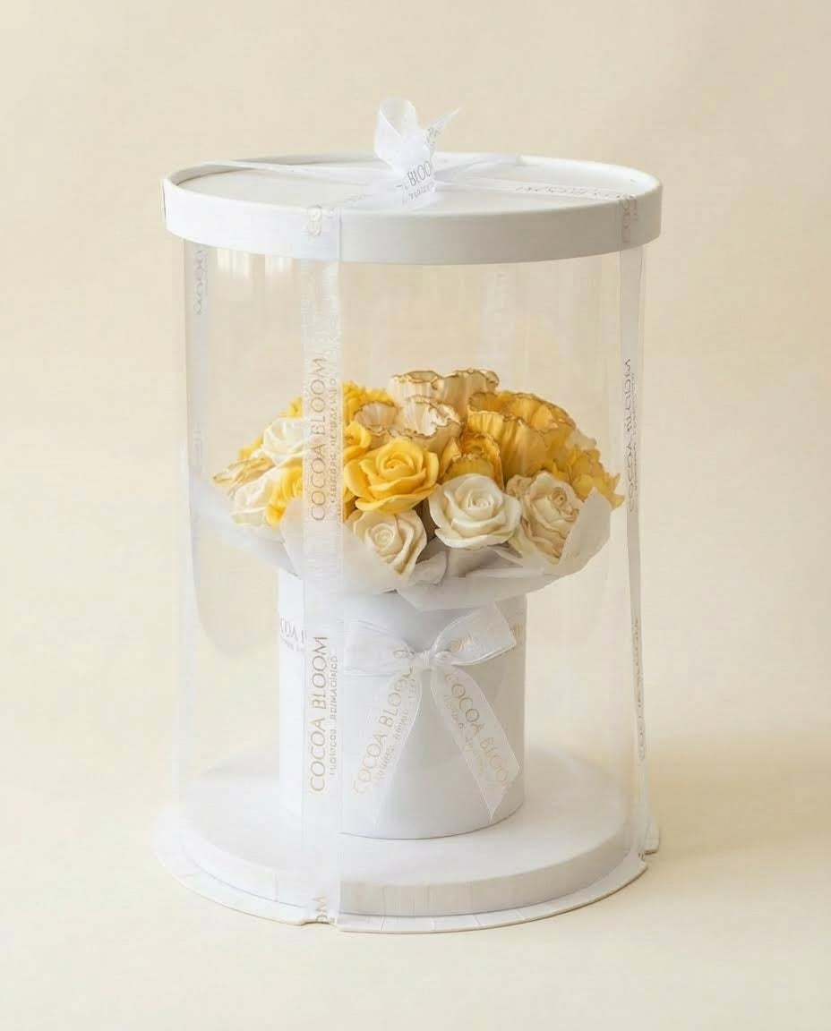 Bouquet of yellow and white 3D chocolate roses in a transparent cylindrical box on a beige background